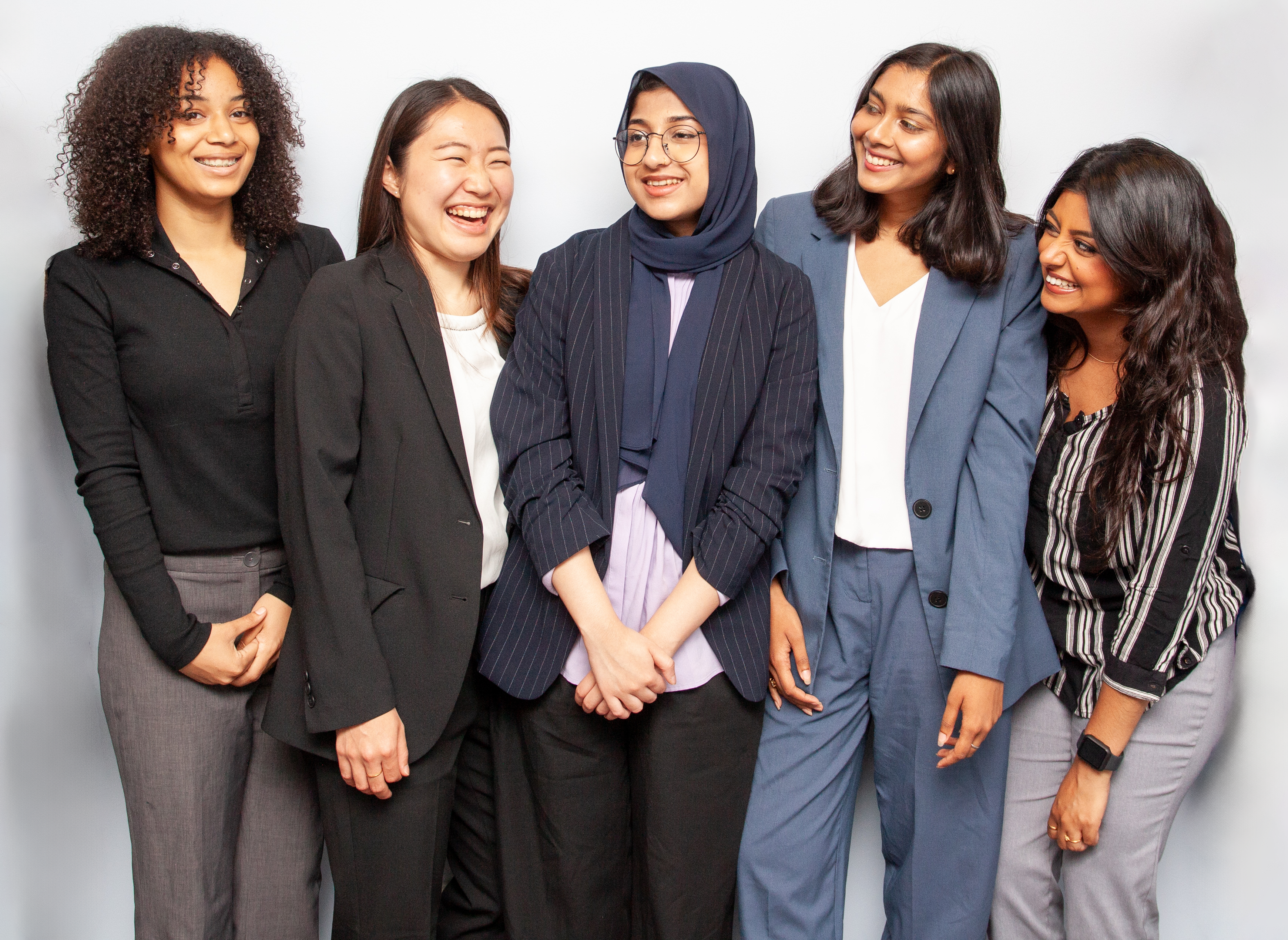 team photo girls Diverse group of professional women smiling in business attire.